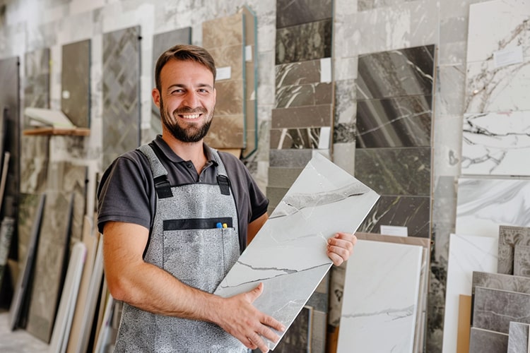 Freundlicher Fliesenleger mit Mosaikfliese in der Hand