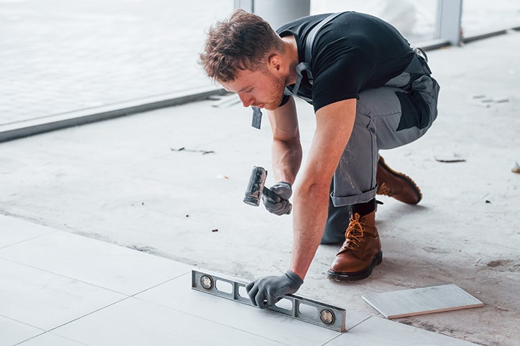 Fliesenleger legt Fliesen